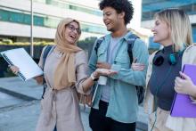 one woman with a hijab, a black man, and a white woman walk 