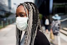 image of black woman with white and black braids and a facemask