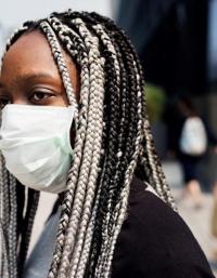 image of black woman with white and black braids and a facemask