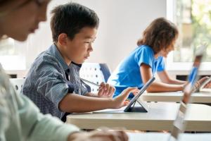 Masculine-presenting Asian student in class