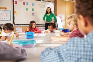 Teacher instructing elementary school kids in classroom