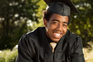 Masculine-presenting Black student in a graduation cap and gown